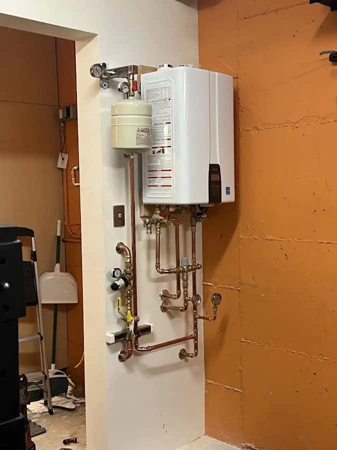 Plumbing technician inspecting water heater connections in Belle Chasse